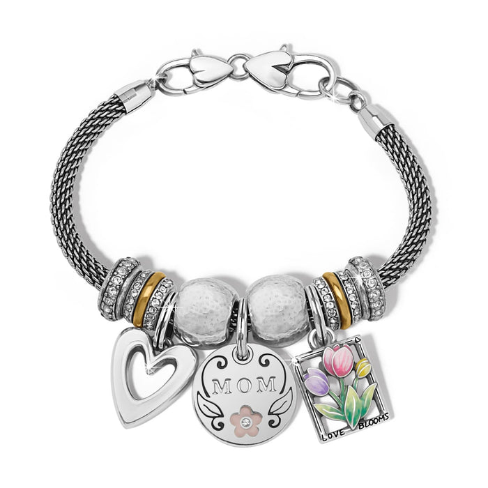 Brighton charm bracelet with silver-plated mesh band, crystal beads, Mom medallion, heart, and floral charms on a white background