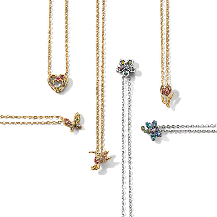 Brighton necklaces styled with gold and silver pendants featuring heart, butterfly, hummingbird, flower, and tulip crystal charms