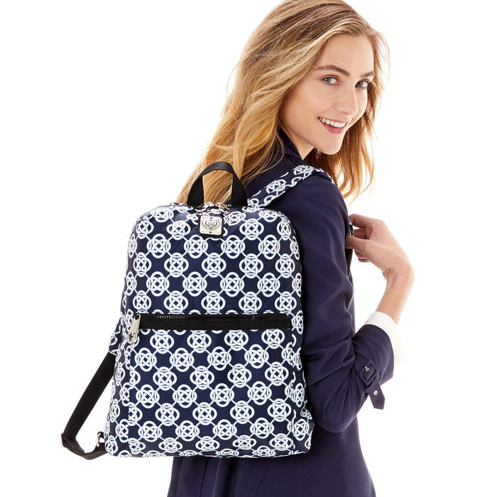 Model with a Brighton backpack featuring navy and white interlocking circle print with front zip pocket