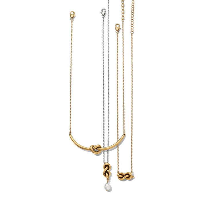 Brighton three necklaces with gold-plated knotted bar, silver chain knot pendant with pearl drop, and gold knot on a white background