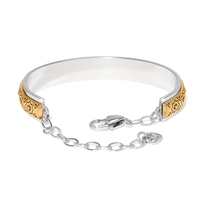 Brighton bangle bracelet with two-tone finish, engraved gold star motifs, and silver-tone chain clasp on a white background