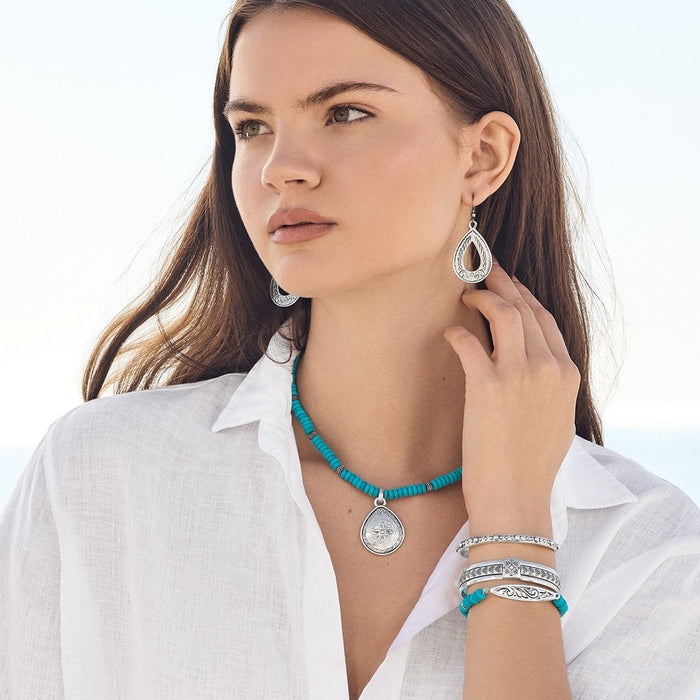 Model wearing Brighton silver-plated teardrop earrings with turquoise beaded pendant necklace and coordinating Brighton accessories