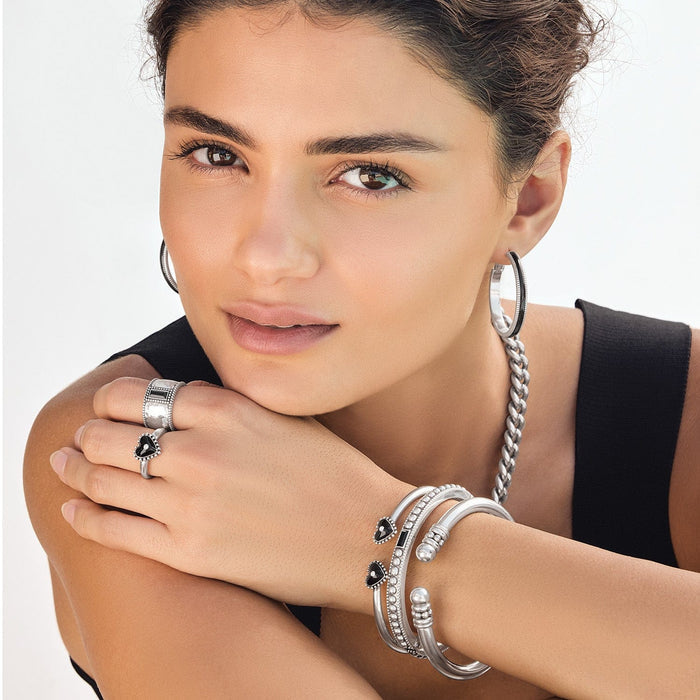 Model wearing Brighton silver-plated hoop earrings with coordinating Brighton accessories including bangles, rings, and a chain necklace