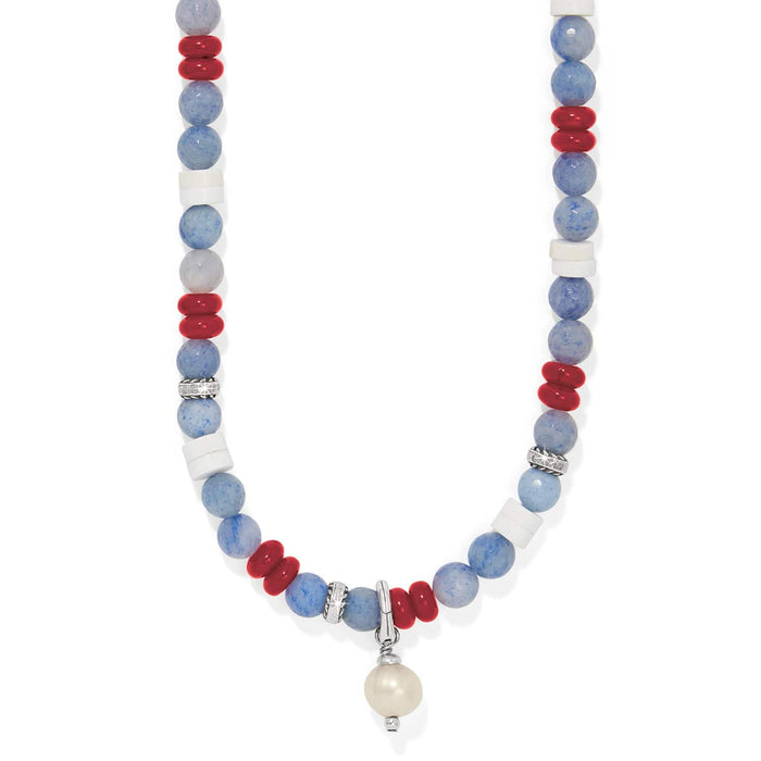 Brighton beaded necklace with blue, red, and white beads, silver-plated accents, and pearl drop on a white background