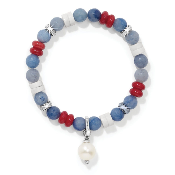 Brighton beaded bracelet with blue, red, and white stones, silver-plated accents, and pearl drop charm on a white background