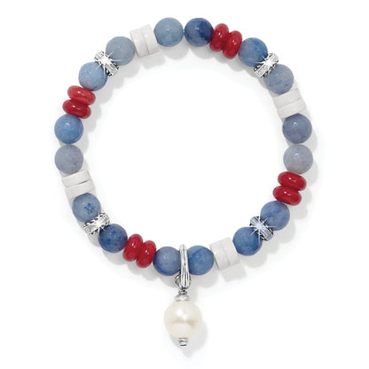 Brighton beaded bracelet with blue, red, and white stones, silver-plated accents, and pearl drop charm on a white background