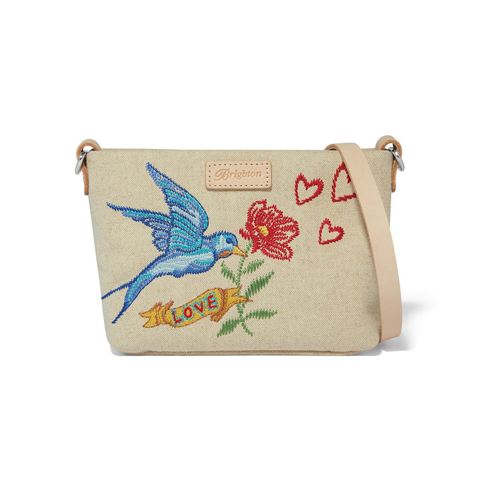 Brighton crossbody handbag in beige canvas with embroidered bluebird, red flower, hearts, and Love banner on a white background