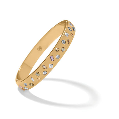 Brighton gold-plated bangle bracelet with scattered multicolored crystals in various shapes and sizes on a white background