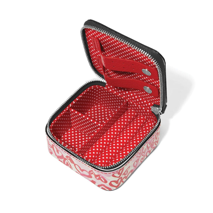 Brighton jewelry case shown open with red polka dot interior, heart print exterior, and zipper closure on a white background