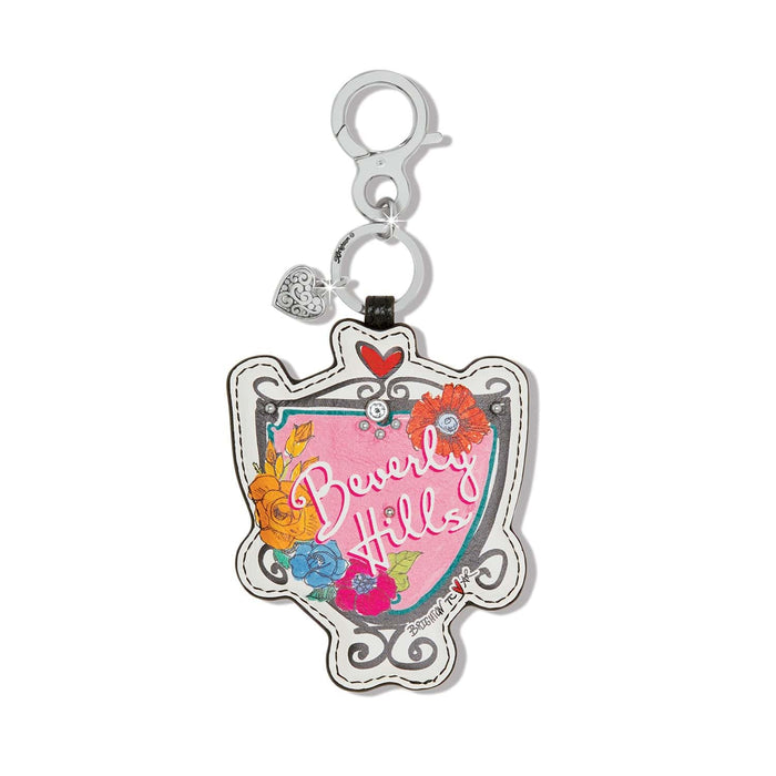 Brighton leather bag charm with Beverly Hills shield design, floral print, and silver-tone clasp on a white background