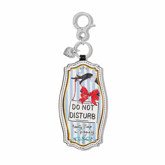 Brighton leather bag charm with Do Not Disturb sign illustration, red bow, and silver heart accent on a white background