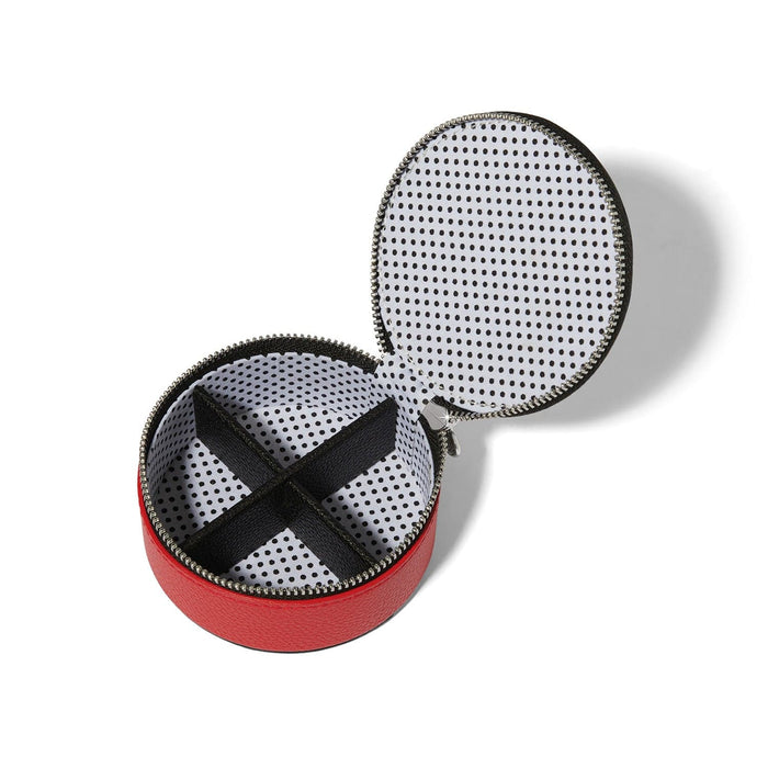 Brighton round red leather jewelry case shown open with black polka dot lining and divided compartments on a white background