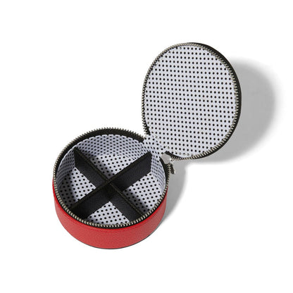 Brighton round red leather jewelry case shown open with black polka dot lining and divided compartments on a white background