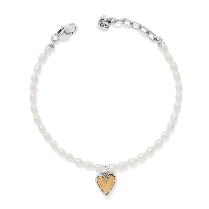 Brighton bracelet with rice pearls, two-tone heart charm, silver-tone clasp, and chain extender on a white background