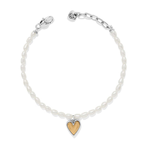 Brighton bracelet with rice pearls, two-tone heart charm, silver-tone clasp, and chain extender on a white background