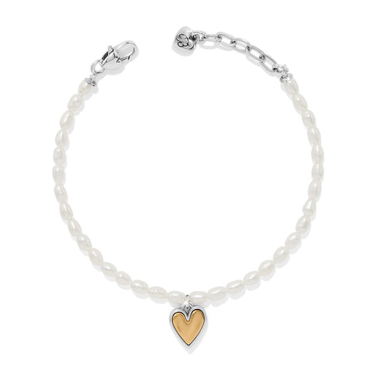 Brighton bracelet with rice pearls, two-tone heart charm, silver-tone clasp, and chain extender on a white background