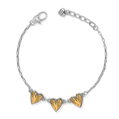 Brighton bracelet with three gold-tone heart charms and silver-tone chain with lobster clasp on a white background