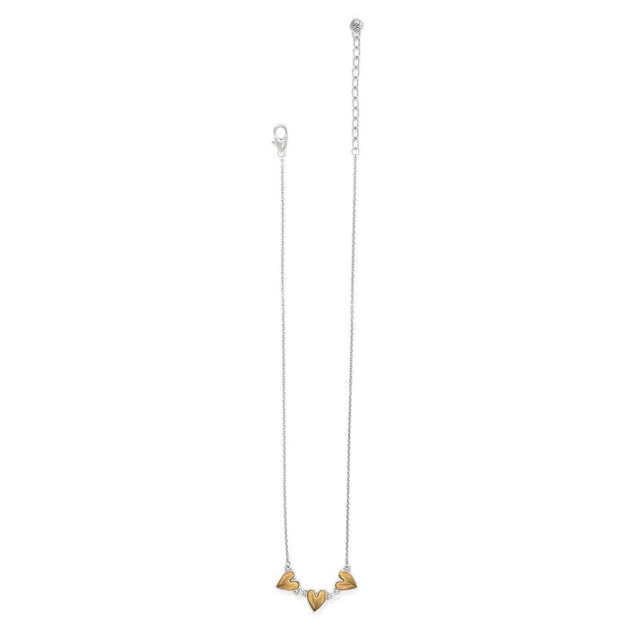 Brighton necklace with three gold-tone heart pendants, silver-tone chain, and lobster clasp on a white background