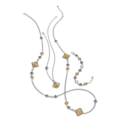 Brighton two-tone jewelry set styled with floral clover stations, crystal accents, and matching bracelet on white background