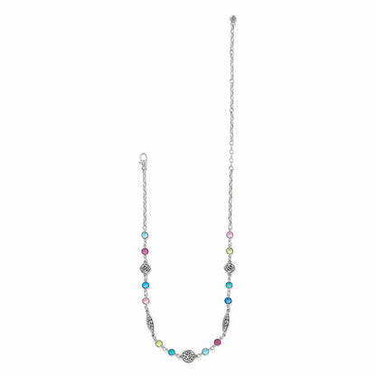 Brighton silver-plated necklace with multicolored crystal stations and ornate scroll medallions on a white background