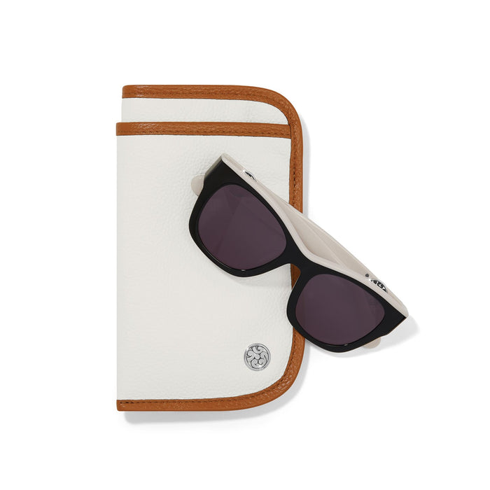 Brighton white and tan leather eyeglass case styled with black sunglasses and silver-plated medallion accent on white background