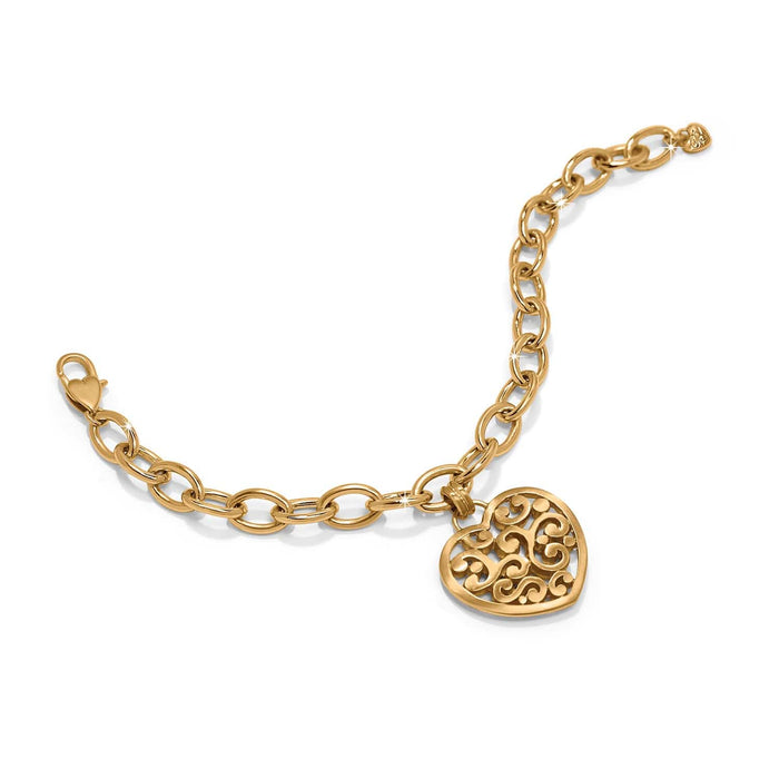 Brighton charm bracelet with gold-plated oval link chain and filigree heart pendant on a white background