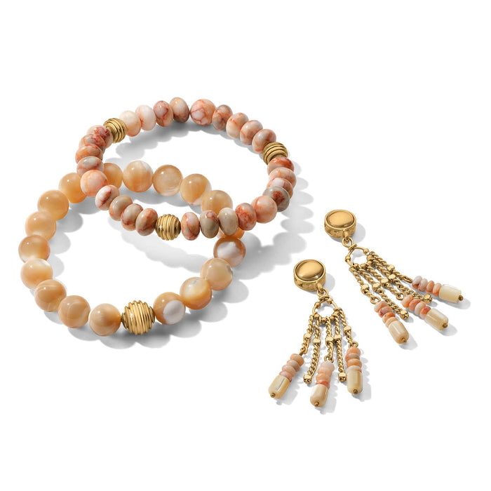 Brighton beaded bracelets with cream and red-veined beads and gold-plated accents, with tassel charms on a white background
