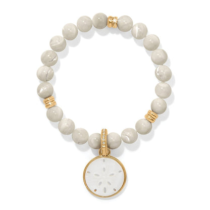 Brighton beaded bracelet with cream stone beads, gold-plated accents, and mother-of-pearl sand dollar charm on a white background
