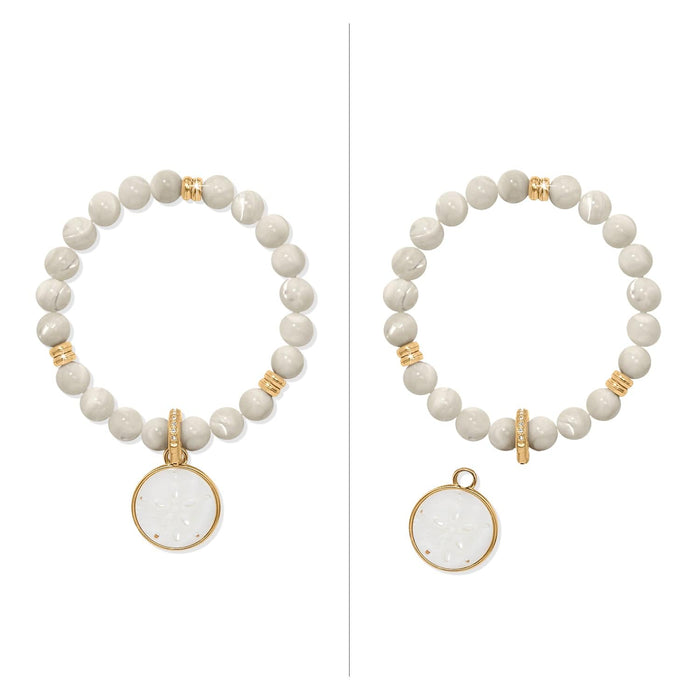 Brighton beaded bracelet with cream beads, gold-plated accents, and detachable mother-of-pearl sand dollar charm on a white background