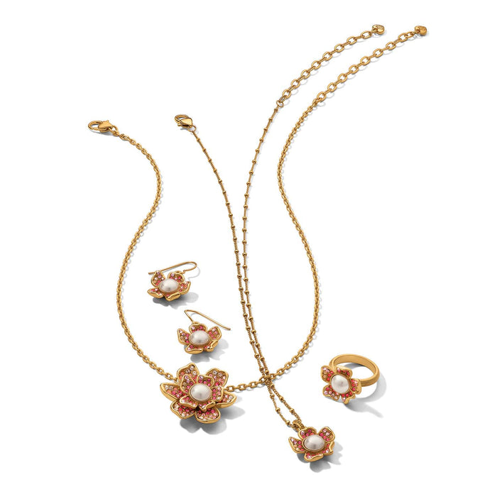 Brighton gold-plated jewelry set with floral pendants, glass pearl cabochons, and pink crystal accents on a white background
