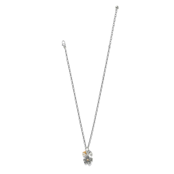 Brighton charm necklace with two-tone flower pendant, glass pearl, and bead accents on a white background