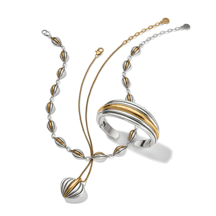Brighton two-tone jewelry set styled with a beaded necklace, cuff bracelet, and pendant on a white background