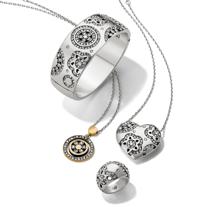 Brighton silver-plated jewelry set styled with a hinged bangle, heart pendant necklace, medallion necklace, and ring with crystals