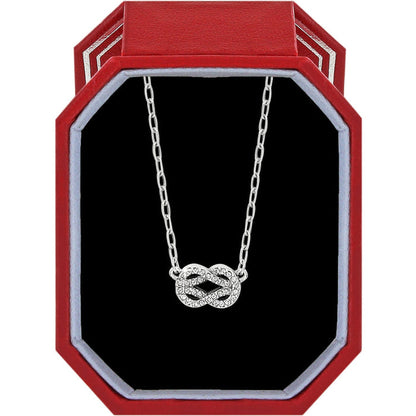 Brighton silver-plated necklace with crystal infinity knot pendant displayed in a red gift box on a white background