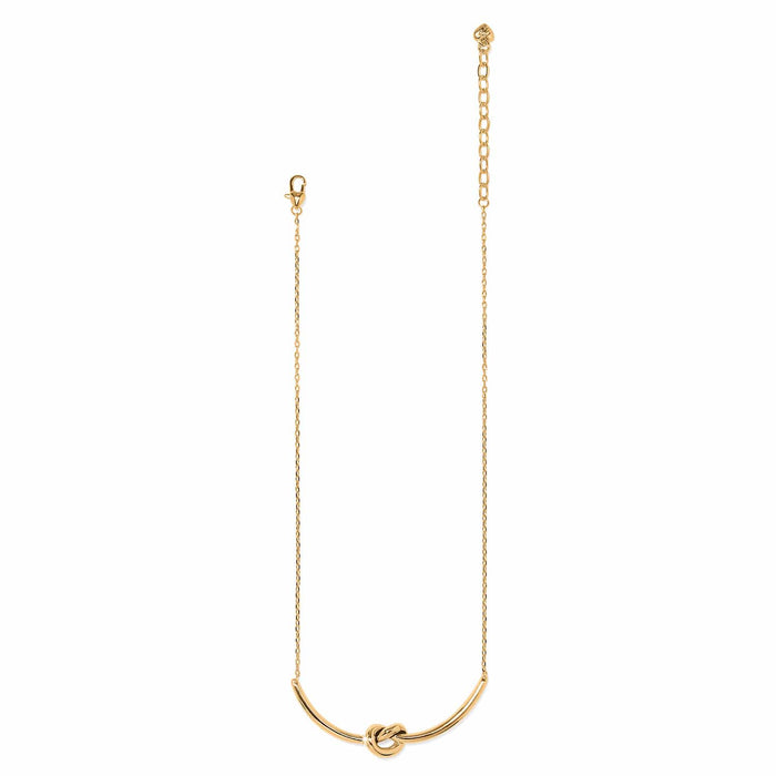 Brighton gold-plated necklace with curved bar pendant featuring a center knot detail and lobster clasp on a white background
