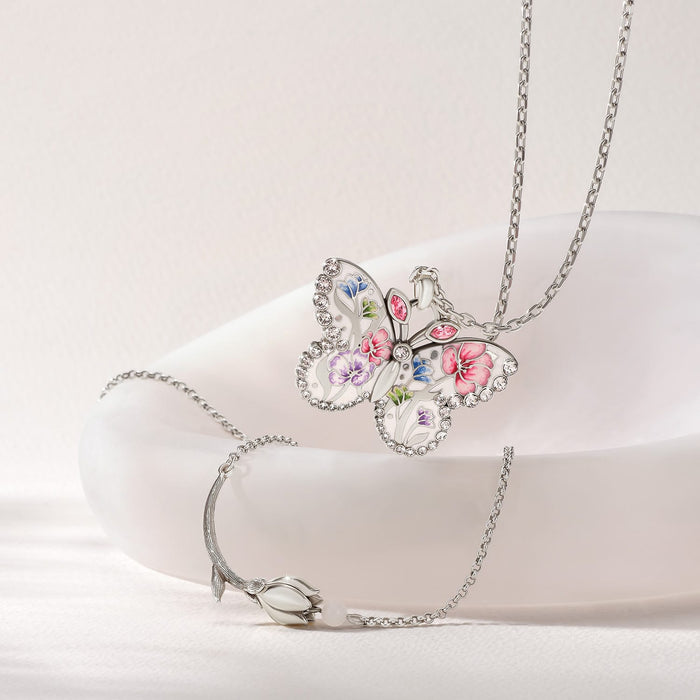 Brighton butterfly pendant necklace with floral enamel design and crystals, styled with a silver-plated tulip bracelet