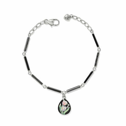Brighton silver-plated bracelet with black enamel bar links and tulip enamel teardrop charm with crystals on a white background