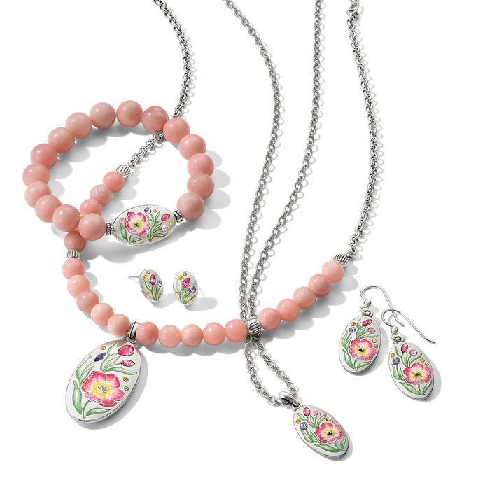 Brighton silver-plated jewelry set styled with pink beaded bracelets and floral enamel pendants featuring crystal accents on white