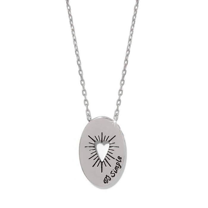 Brighton silver-plated oval pendant necklace with cut-out heart, sunburst engraving, and script text on a white background