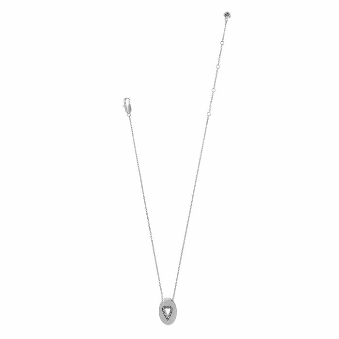 Brighton silver-plated pendant necklace with oval charm and crystal heart cutout detail on a white background