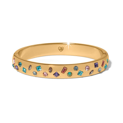 Brighton gold-plated bangle bracelet with scattered multicolored crystals in various shapes and sizes on a white background