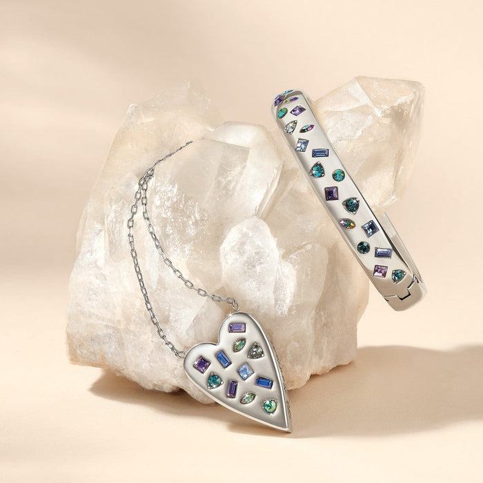 Brighton silver-plated heart pendant necklace and crystal bangle bracelet styled with a quartz crystal on neutral background