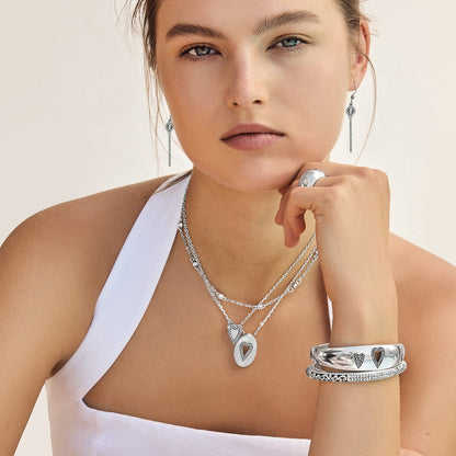 Model wearing Brighton silver-plated heart pendant necklaces with crystal accents and coordinating Brighton earrings, bracelets, and ring