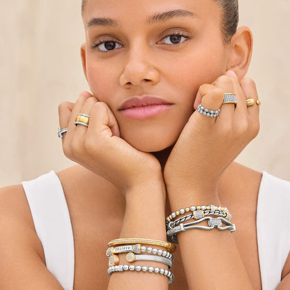 Model wearing Brighton silver and gold-plated rings and stacked bracelets with crystal accents and beaded details