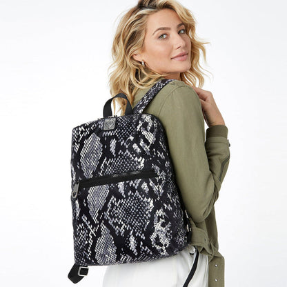 Model with a Brighton backpack in black and white snakeskin print with front zip pocket