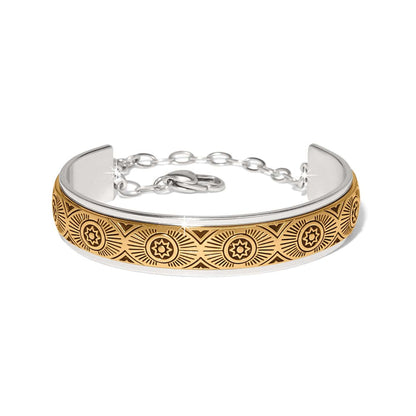 Brighton cuff bracelet with two-tone finish featuring engraved gold sunburst medallion pattern and silver chain closure on a white background