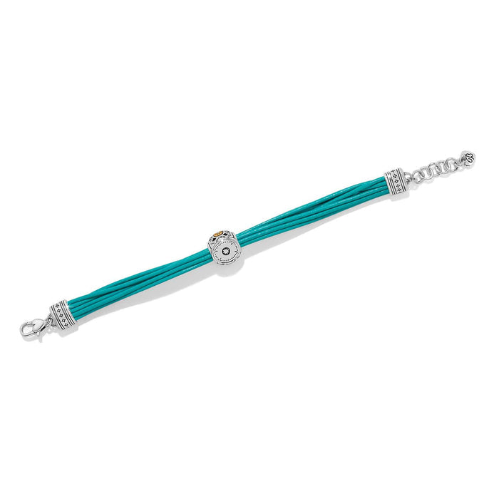 Brighton bracelet with teal leather cords, two-tone decorative bead, and silver-tone end caps on a white background
