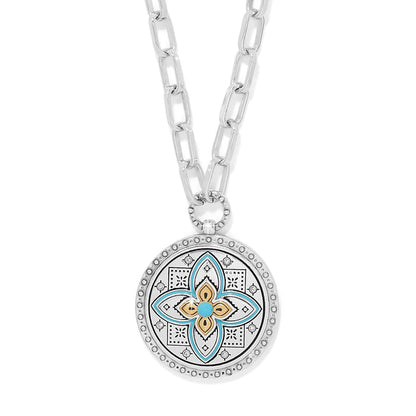 Brighton pendant necklace with two-tone medallion, turquoise enamel floral motif, crystals, and silver-tone chain on a white background