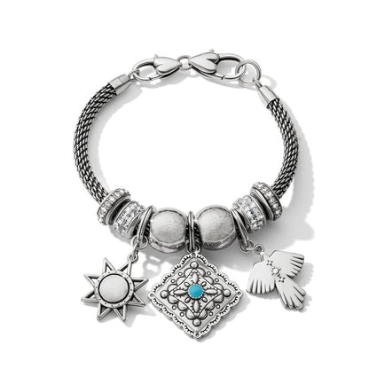 Brighton charm bracelet with silver-plated mesh band, crystal accents, star, medallion, and bird charms on a white background