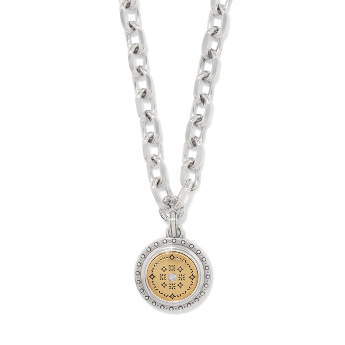 Brighton pendant necklace with two-tone medallion, gold patterned center, crystal accent, and silver chain on a white background